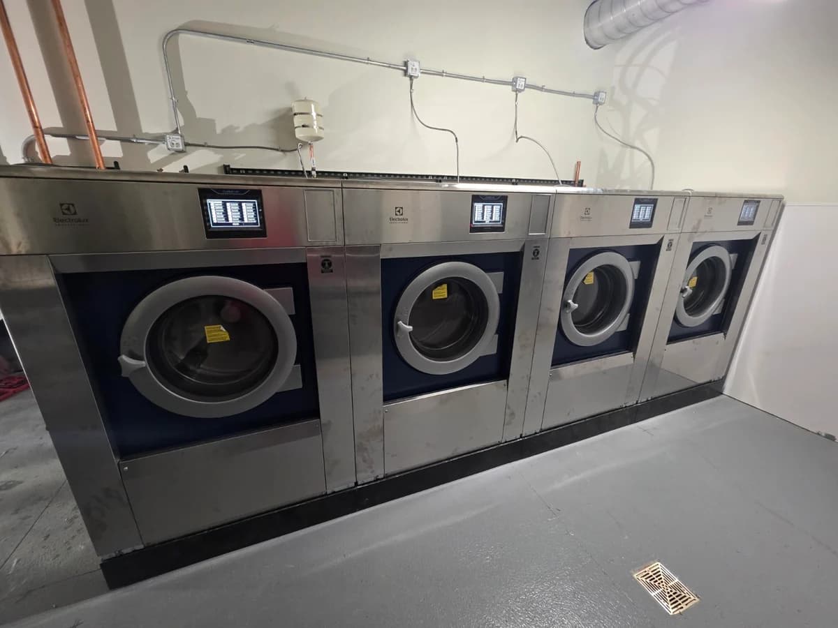 Four Electrolux Professional commercial washers installed in a row
