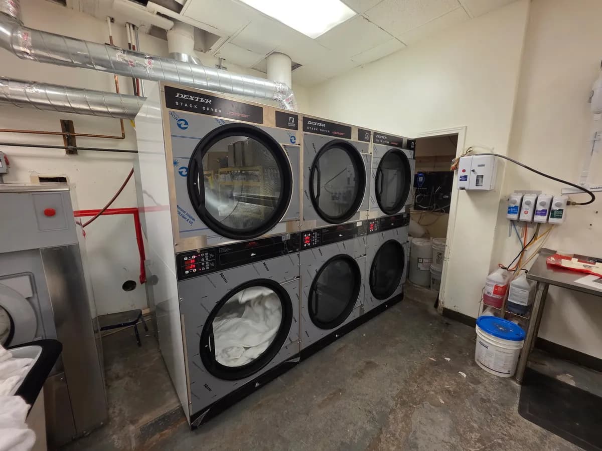 Newly installed stacked dryers in a back-room laundry